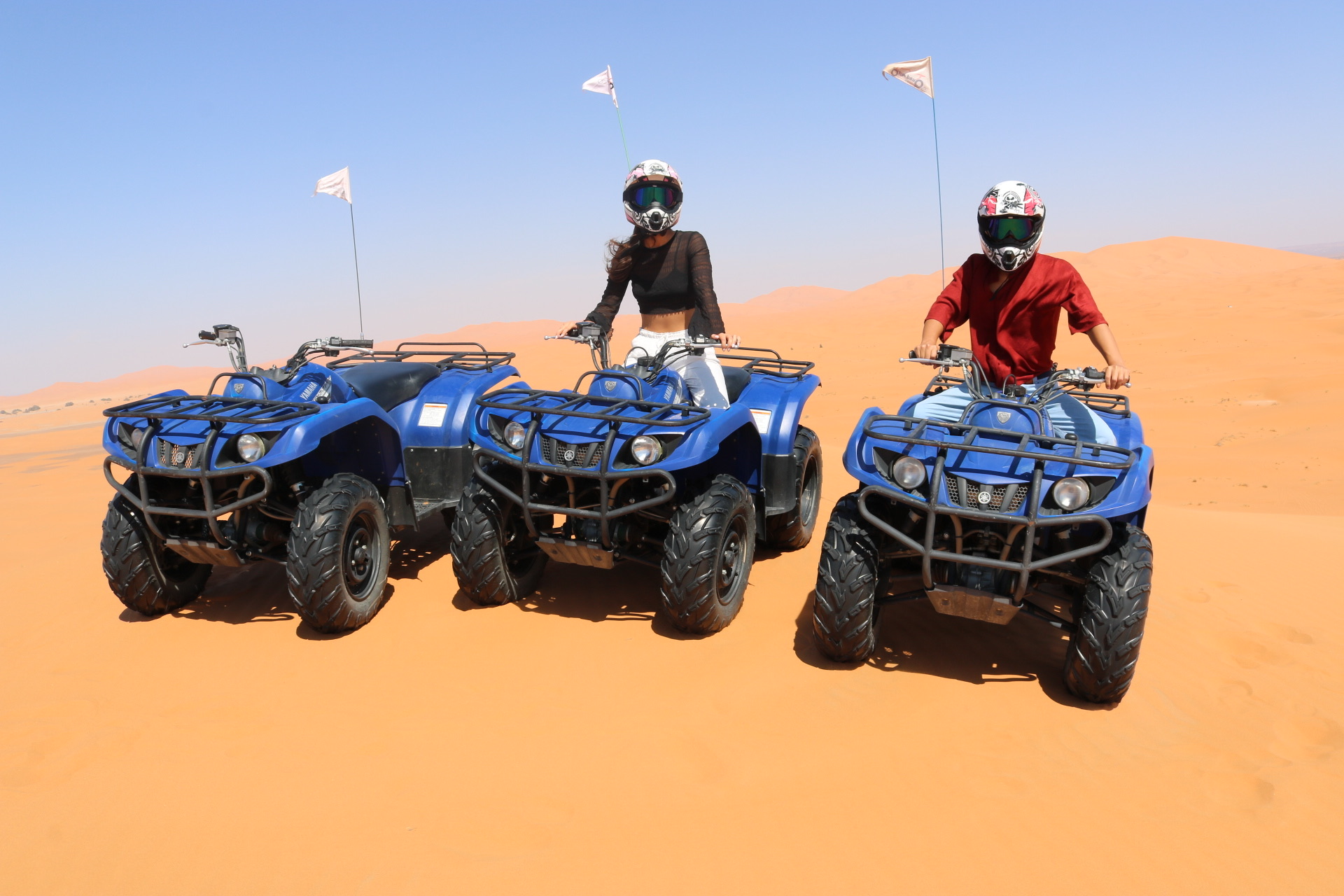 Riding blue quad bikes across orange desert dunes