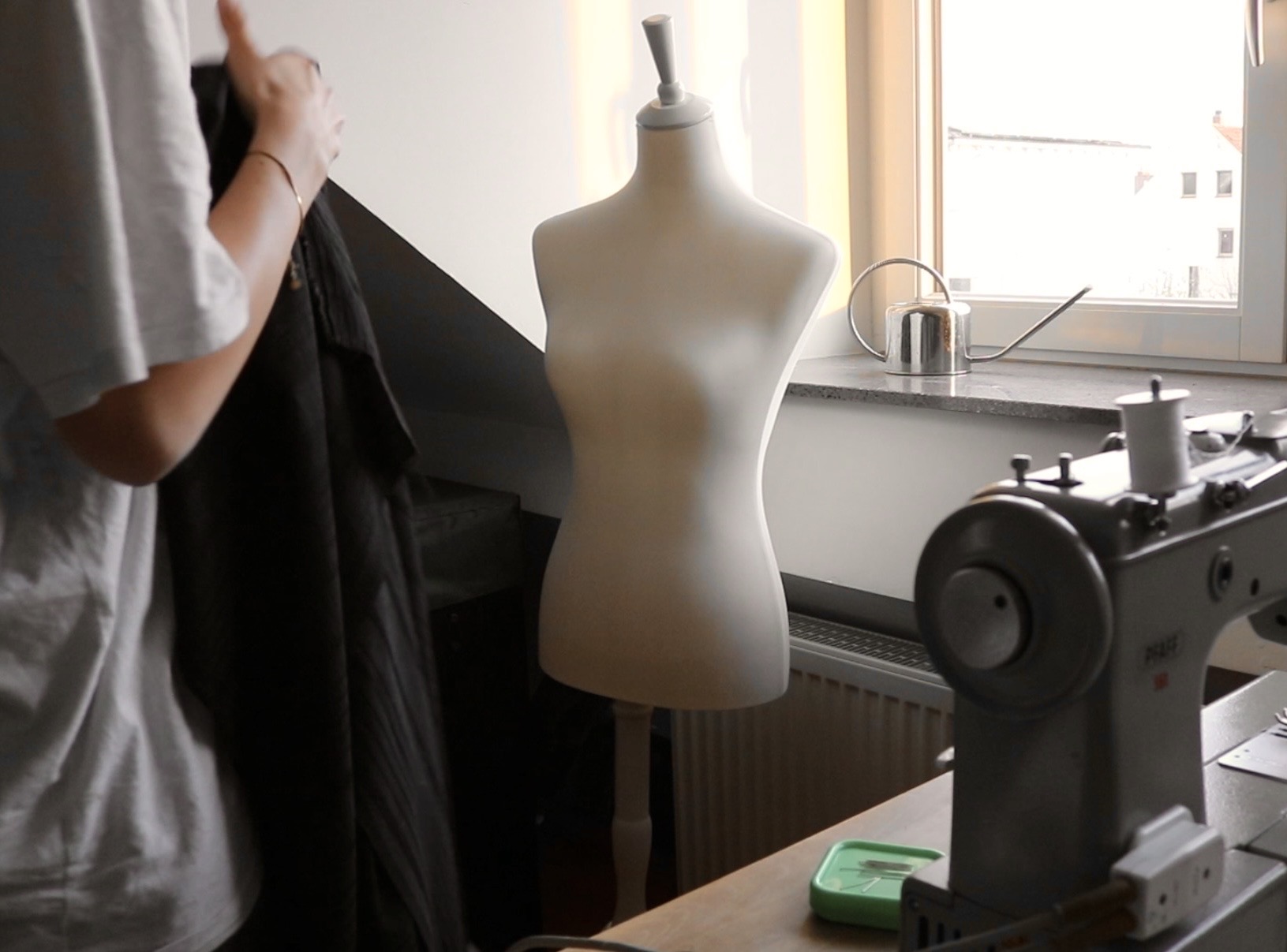 Sewing atelier with a dress form by the window and an industrial sewing machine