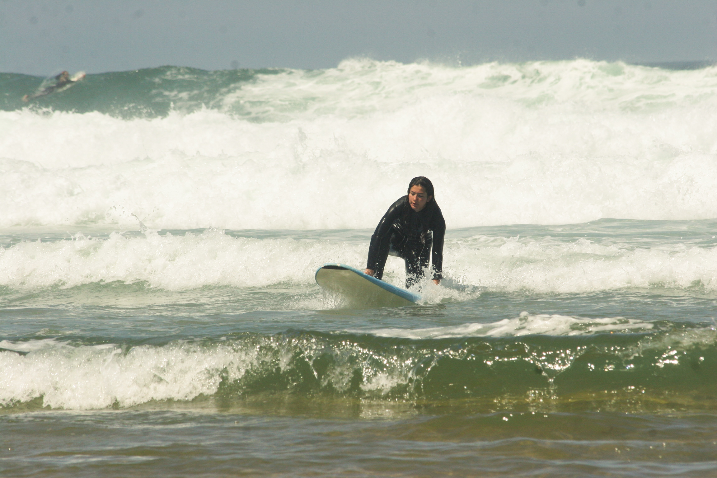 Surfing a breaking wave in a black wetsuit
